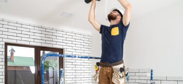 electrician-builder-work-installation-lamps-height-professional-overalls-with-drill-repair-site-1024x691